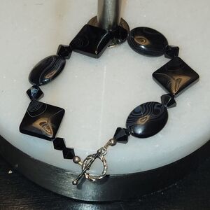 Black 8 inch unbranded toggle, (tested) Tourmaline,Garnet? Wired bracelet.